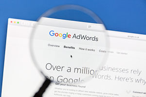 Magnifying glass looking over the benefits of paid ads vs organic seo