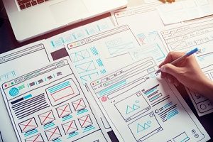 Web designers planning a website's pages using UX wireframes