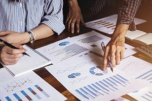 Businessman reviewing marketing analytics with his coworkers to determine how to more effectively target his audience