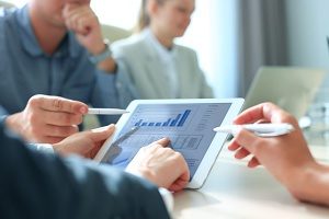 workers analyzing company data on their tablet to help develop a strategy for lead generation