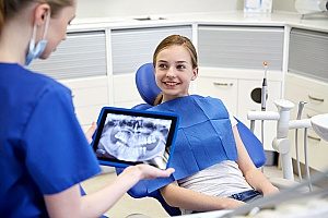 a dentist checking the x-ray of a new patient who found his practice through good dental SEO marketing employed by a trusted dental marketing agency