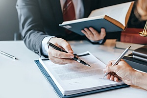 an attorney signing paperwork with a client who discovered the firm online