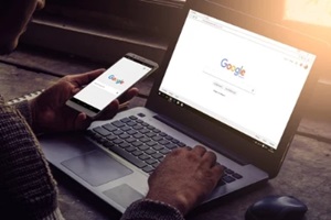 man using google in laptop and mobile