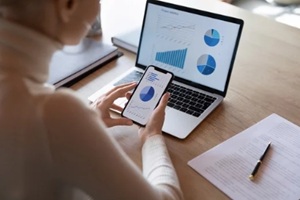 businessman analyzing charts in laptop and mobile